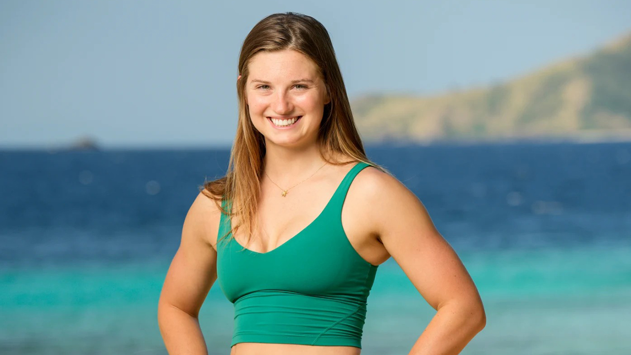 Eva from Survivor 48 posing on the beach with her hands on her hips.