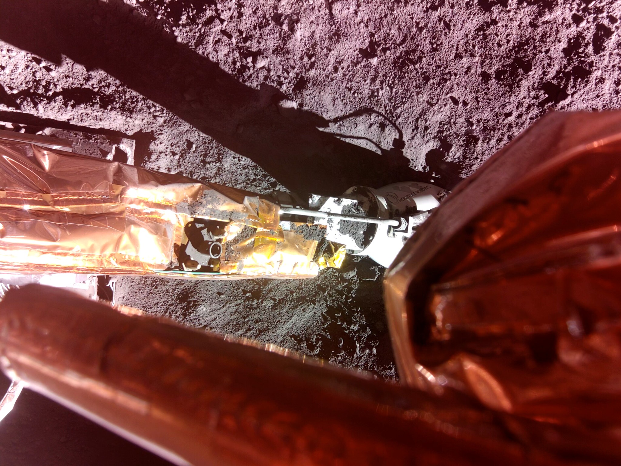 The Lunar PlanetVac instrument, developed by Honeybee Robotics, was deployed to the lunar surface and is shown at the end of Blue Ghost’s surface access arm. 