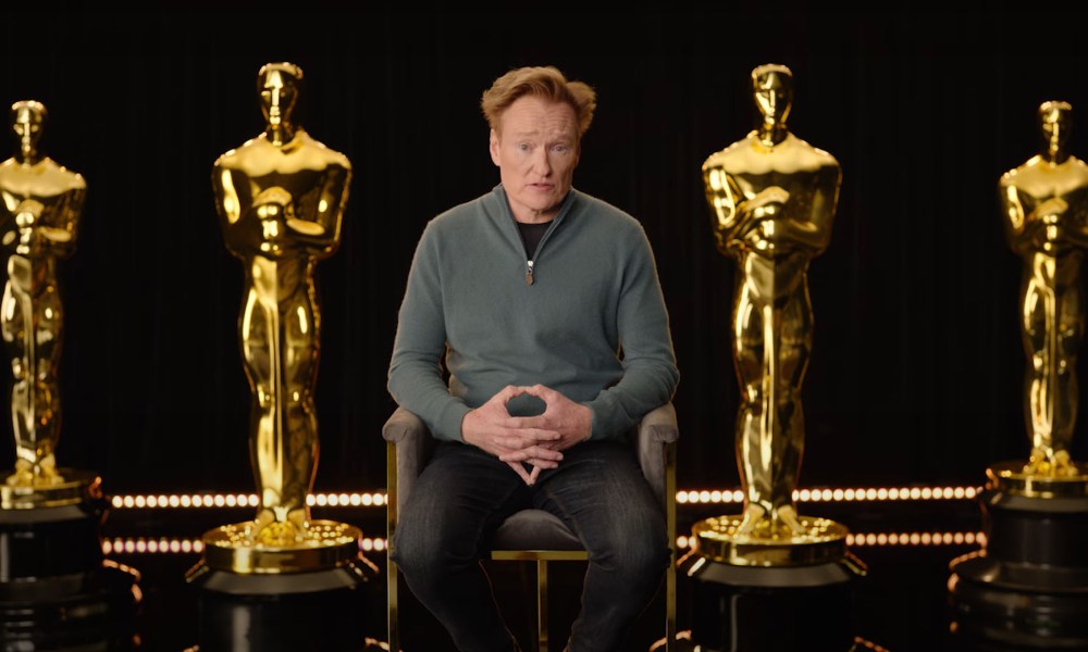 Conan O'Brien sits among giant Oscars.