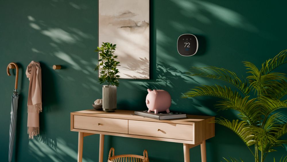 el Ecobee Smart Thermostat Essential en una pared verde