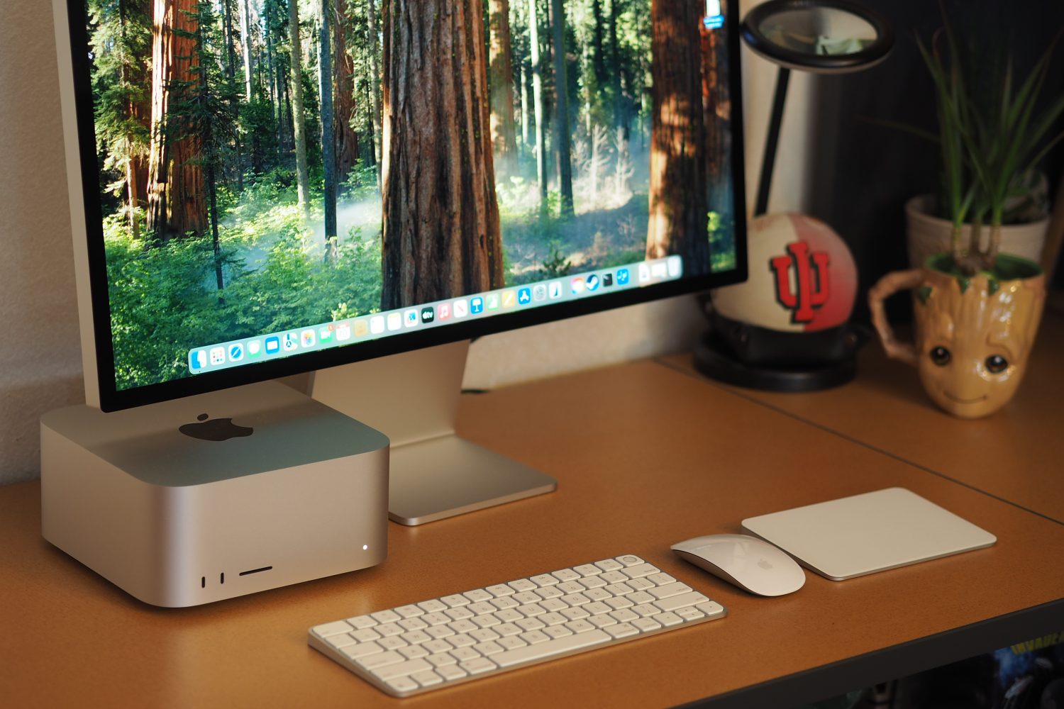 Vue avant d'Apple Mac Studio 2025 montrant le bureau, le moniteur, le clavier, la souris et le pavé tactile.