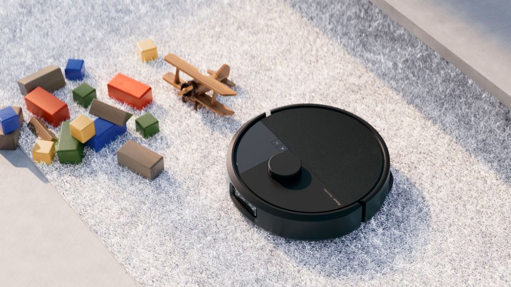 The new Roomba vacuuming on a rug.